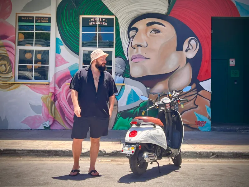 Guide Mikhail in front of a portrait mural in Wynwood, Miami