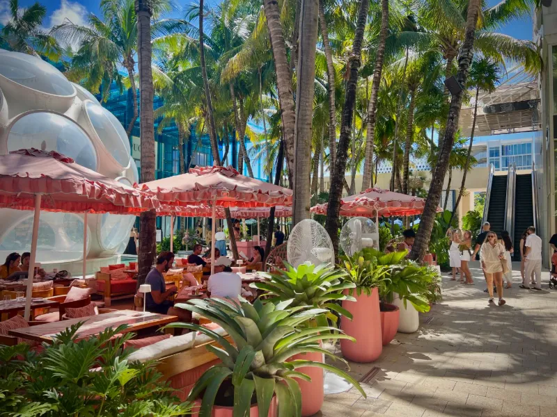 Outdoor lounge with pink umbrellas on a plaza in the Miami Design District