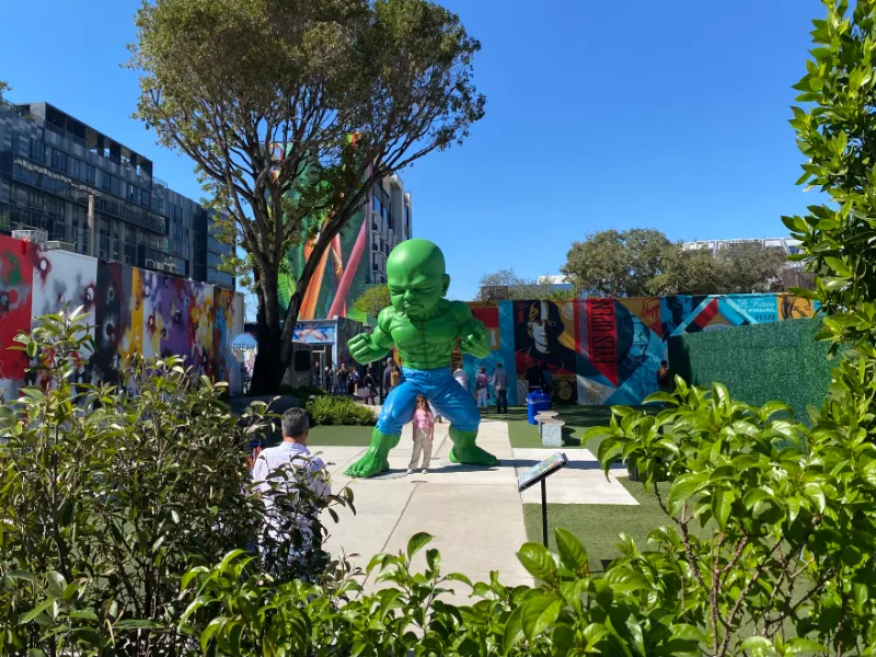 Green baby sculpture among murals inside the Wynwood Walls, Miami